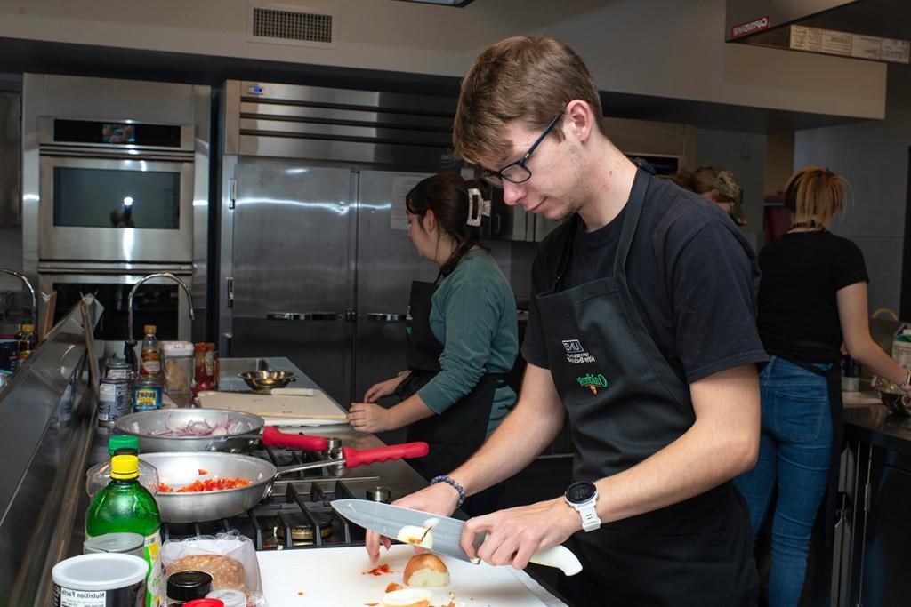 A nutrition student cutting an onion