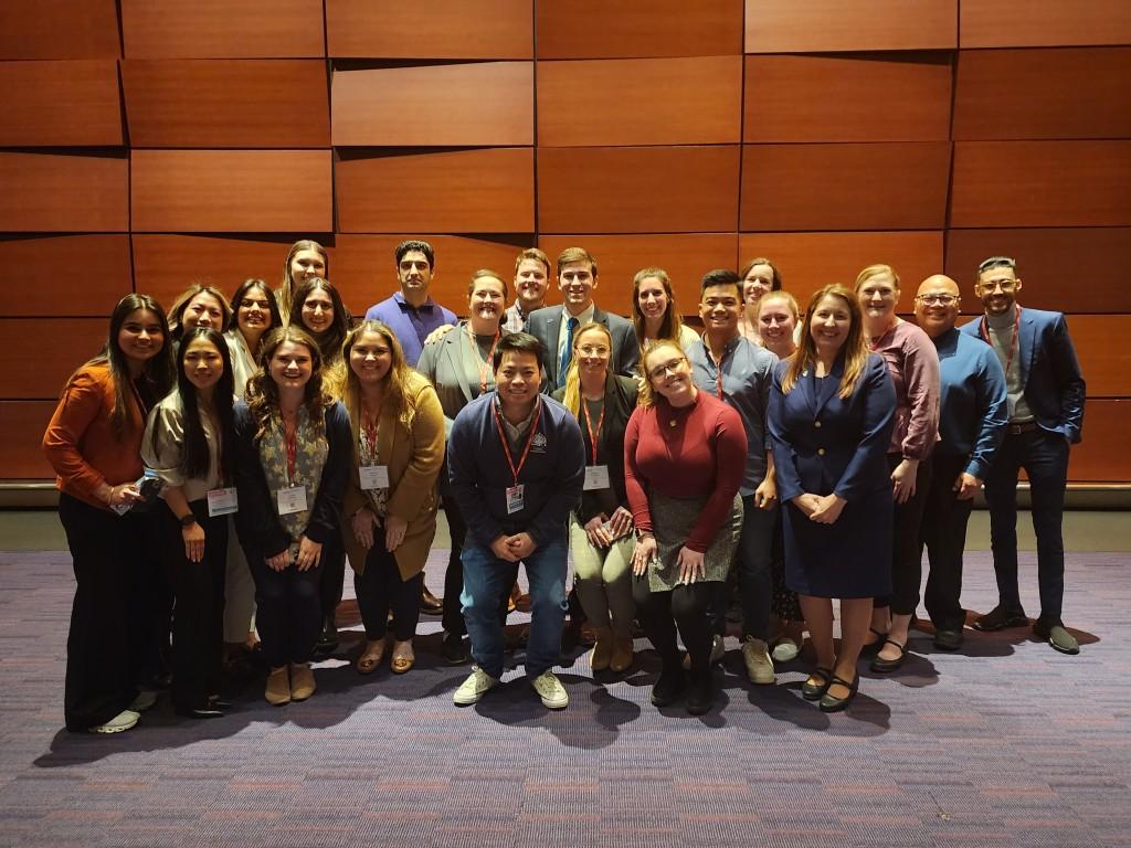 Debate participants pose for a group photo on stage