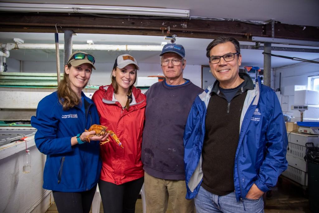 UNE's Charles Tilburg and Lindsay Forrette pose with the lobster and Capt. Gregg and Mandy Cyr