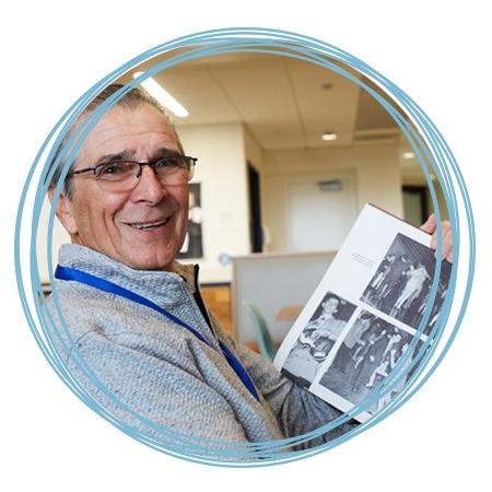 一个圣. Francis alumnus looks through a yearbook at 首页coming