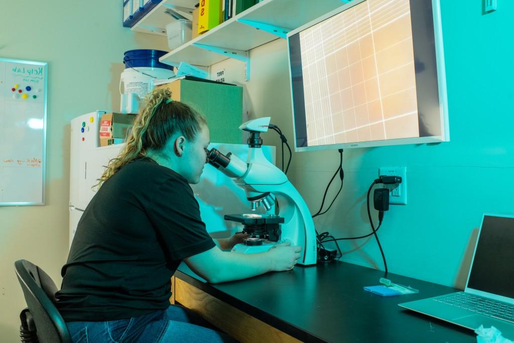 student looking into microscrope