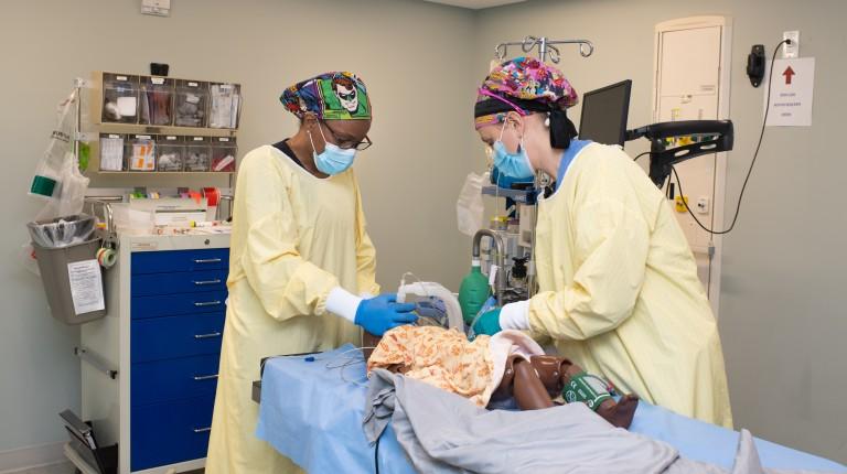 Two Nurse Anesthesia students practice on a simulator in UNE's clinical simulation center