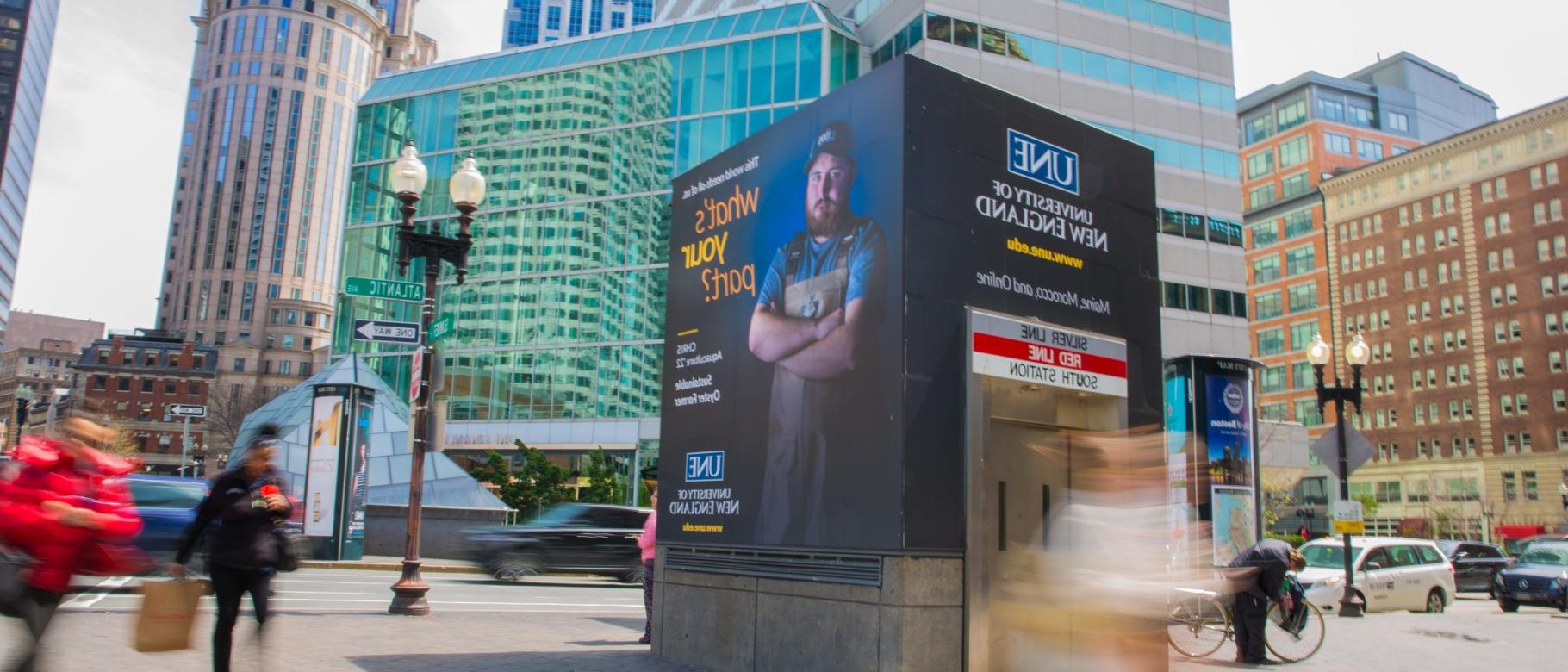 A UNE advertisement adorns a subway entrance in downtown Boston, Mass.