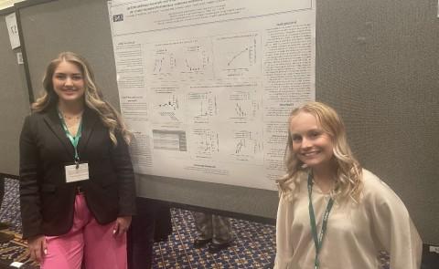 莉莉班纳特, “25(左), and Hannah LaCourse, ‘23 (right) at the 2023 USASP meeting at Duke University in front of their poster.