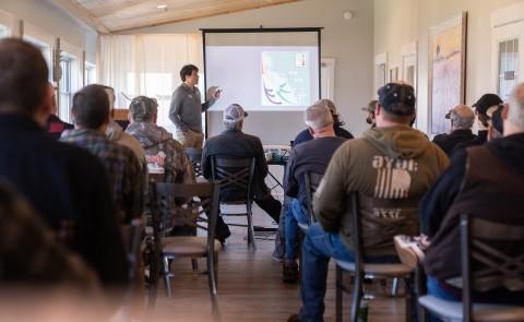 A student presents a slideshow to a room of people