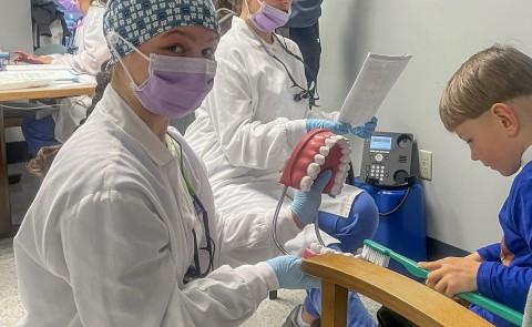 Dental Hygiene students and faculty interact with a family at a local WIC center